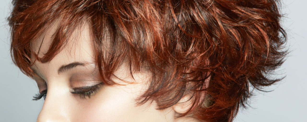 Short choppy shag brunette colored with red copper highlights throughout.